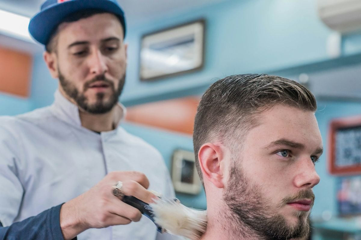 Barbero perfilando el corte de pelo de un cliente en la barbería