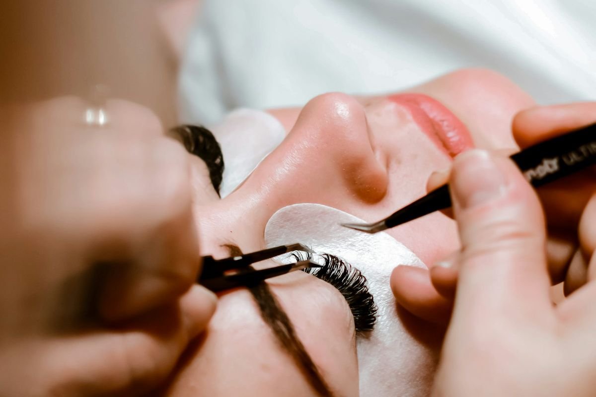 Técnica aplicando extensiones de pestañas con pinzas a una clienta